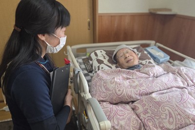 梅田みつよさん（左）の訪問を受け、穏やかな表情を浮かべる男性。末期がんだったが、状態に見合う要介護認定が間に合わないまま、3月初旬に亡くなった＝岐阜県白川町で2026年1月29日、宇多川はるか撮影