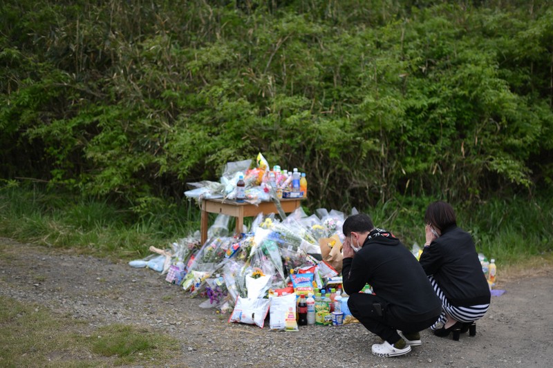 安達結希さんの遺体が見つかった現場付近で手を合わせる人たち＝京都府南丹市で2026年4月22日午後2時11分、久保玲撮影