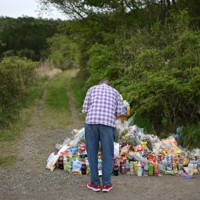 安達結希さんの遺体が見つかった現場付近で頭を下げる男性＝京都府南丹市で2026年4月22日午後1時49分、久保玲撮影