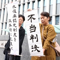 控訴が棄却され、「不当判決」と書かれた紙を掲げる支援者＝福岡市の福岡高裁前で2026年4月23日午後2時5分、金澤稔撮影