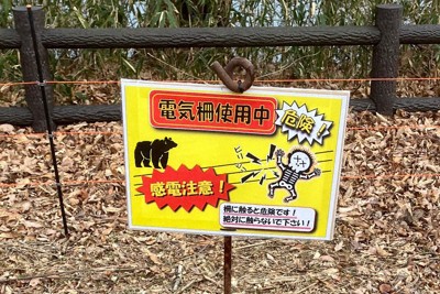 キャンプ場周辺に設置された電気柵と注意を呼びかける看板＝宮城県川崎町で（みちのく公園管理センター提供）