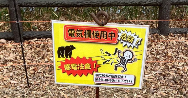 キャンプ場周辺に設置された電気柵と注意を呼びかける看板＝宮城県川崎町で（みちのく公園管理センター提供）