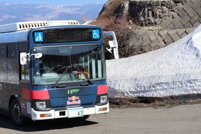 雪の回廊を通って岩木山8合目に向かうバス＝青森県弘前市の岩木スカイラインで2026年4月23日午前8時52分、山越峰一郎撮影