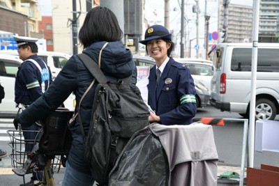 自転車に乗っている人に声をかけ、反則金制度の説明をする警察官＝東京都江戸川区松島1で2026年3月10日午後1時34分、菅野蘭撮影