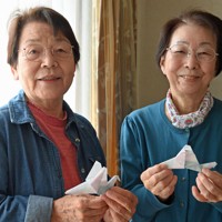 折り紙で折ったハトを手にする山下しのぶさん（左）と今井セイ子さん＝大阪府寝屋川市で2026年4月18日、川平愛撮影