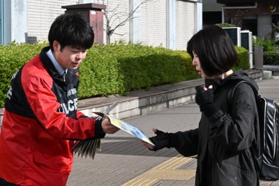 仙台市地下鉄泉中央駅前で通行人にチラシを渡す警察官＝仙台市泉区で2026年4月24日午前7時45分、岩田優希撮影