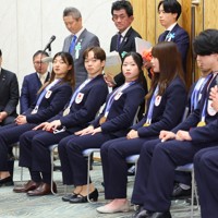 首相表敬訪問で視界を遮らないようのけぞる（中央左から）坂本花織さん、鍵山優真さん、中井亜美さん＝首相官邸で2026年4月24日午後6時27分、猪飼健史撮影
