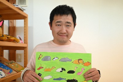 安佐動物公園の広告になった絵の原画を手に持つ上村福銖さん＝広島市安佐南区で2026年4月20日午後3時56分、西山夏奈撮影