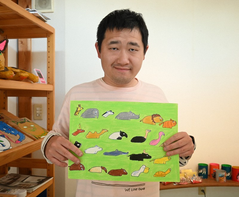 安佐動物公園の広告になった絵の原画を手に持つ上村福銖さん＝広島市安佐南区で2026年4月20日午後3時56分、西山夏奈撮影