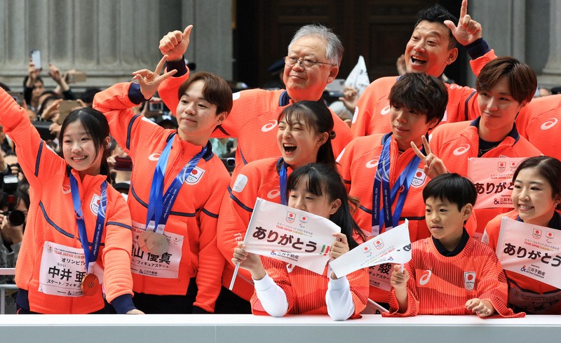ミラノ・コルティナ冬季オリンピック・パラリンピック日本選手団の応援感謝イベントで、日本橋の街を練り歩き観客の声援に応える（左から）フィギュア女子の中井亜美さん、男子の鍵山優真さん、女子の坂本花織さん、男子の佐藤駿さんら選手たち＝東京都中央区で2026年4月25日午前10時4分、滝川大貴撮影
