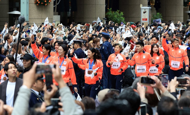 ミラノ・コルティナ冬季オリンピック・パラリンピック日本選手団の応援感謝イベントで、日本橋の街を練り歩き観客の声援に答えるスキージャンプ女子個人ノーマルヒルと混合団体で銅メダルの丸山希さん（中央手前）ら選手たち＝東京都中央区で2026年4月25日午前9時半、滝川大貴撮影