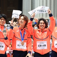 ミラノ・コルティナ冬季オリンピック・パラリンピック日本選手団の応援感謝イベントで、日本橋の街を練り歩き観客の声援に答える（左から）スノーボード男子ビッグエア・スロープスタイルの木俣椋真さん、ハーフパイプの山田琉聖さん、ビッグエア・スロープスタイルの荻原大翔さん、ハーフパイプの戸塚優斗さん＝東京都中央区で2026年4月25日午前9時47分、滝川大貴撮影