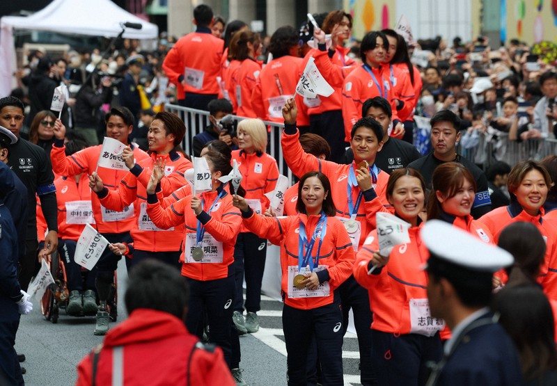 日本橋をパレードするフィギュアスケートペアの三浦璃来さん（右から5人目）、木原龍一さん（同4人目）らミラノ・コルティナオリンピック、パラリンピックの日本代表選手たち＝東京都中央区で2026年4月25日午前10時5分、猪飼健史撮影