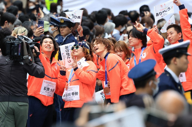 ミラノ・コルティナ冬季オリンピック・パラリンピック日本選手団の応援感謝イベントで、日本橋の街を練り歩き観客の声援に答える（左から）スノーボード男子ビッグエア・スロープスタイル銀メダルの長谷川勝さん（左から2人目）ら選手たち＝東京都中央区で2026年4月25日午前9時44分、滝川大貴撮影