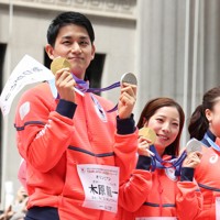 ミラノ・コルティナ冬季オリンピック・パラリンピック日本選手団の応援感謝イベントで、日本橋の街を練り歩きメダルを手にするフィギュアスケートペアで金メダルの三浦璃来さん、木原龍一さん＝東京都中央区で2026年4月25日午前9時57分、滝川大貴撮影