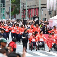 日本橋をパレードするパラアルペンスキーの村岡桃佳さん（手前左端）、森井大輝さんらミラノ・コルティナオリンピック、パラリンピックの日本代表選手たち＝東京都中央区で2026年4月25日午前9時47分、猪飼健史撮影