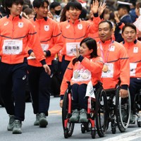 ミラノ・コルティナ冬季オリンピック・パラリンピック日本選手団の応援感謝イベントで、日本橋の街を練り歩き観客の声援に応えるパラアルペンスキーの（右列手前から）村岡桃佳さん、鈴木猛史さんら選手たち＝東京都中央区で2026年4月25日午前9時40分、滝川大貴撮影
