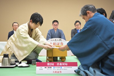 第84期名人戦第2局1日目、立会の行方尚史九段（手前右）に封じ手を手渡す藤井聡太名人（同左）＝青森市のホテル青森で2026年4月25日午後6時51分、吉田航太撮影