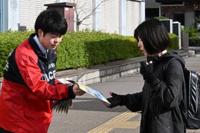 仙台市地下鉄泉中央駅前で通行人にチラシを渡す警察官＝仙台市泉区で2026年4月24日、岩田優希撮影