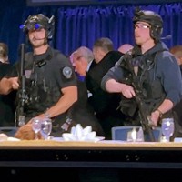 警護担当者に囲まれ、夕食会会場から退避を促されるトランプ米大統領（中央奥）＝ワシントンで2026年4月25日、ロイター
