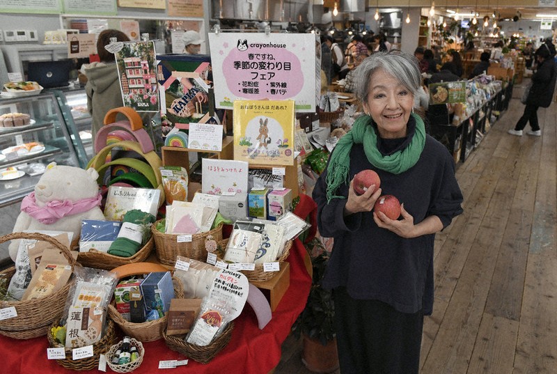 「このリンゴおいしいのよ」。クレヨンハウス東京店の店内に立つ落合恵子さん＝東京都武蔵野市で、宮本明登撮影