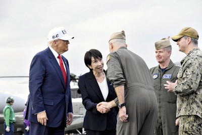 米海軍横須賀基地に停泊中の米原子力空母「ジョージ・ワシントン」に到着し、米軍関係者から歓迎を受ける高市早苗首相（中央）とトランプ米大統領（左）＝神奈川県横須賀市で2025年10月28日午後3時53分（代表撮影）