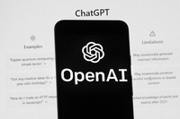 The OpenAI logo is seen on a mobile phone in front of a computer screen which displays the ChatGPT home screen, March 17, 2023, in Boston. (AP Photo/Michael Dwyer, File)