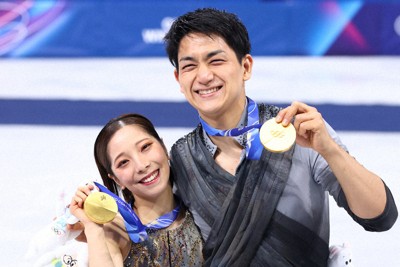 表彰式で金メダルを手に笑顔を見せる三浦璃来選手、木原龍一選手組＝ミラノ・アイススケートアリーナで2月16日