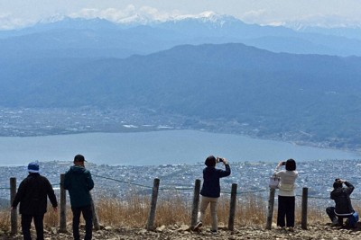 高ボッチ山頂から諏訪湖や南アルプスの眺めを楽しむ観光客＝長野県塩尻市・岡谷市境の高ボッチ高原で、武田博仁撮影