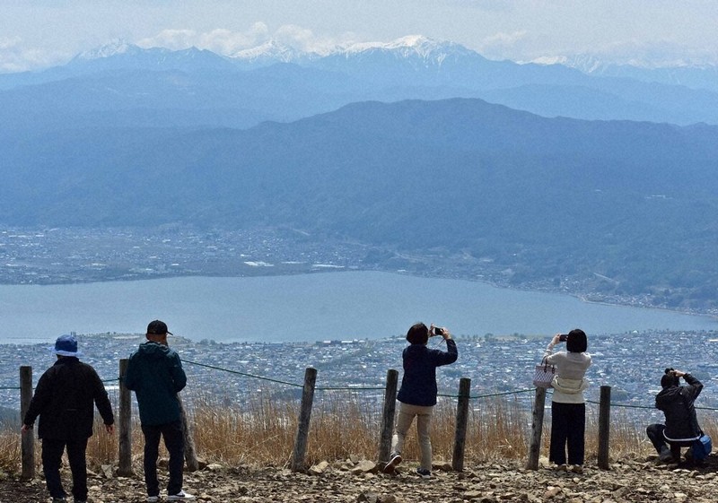 高ボッチ山頂から諏訪湖や南アルプスの眺めを楽しむ観光客＝長野県塩尻市・岡谷市境の高ボッチ高原で、武田博仁撮影