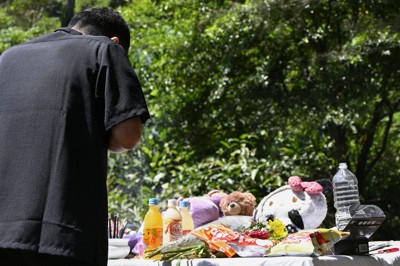　女性の遺体が見つかった現場で手を合わせる父親＝28日午前、沖縄県恩納村