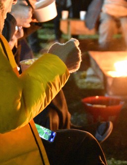 People eat pork and vegetable miso soup and other dishes served at a soup kitchen beside a bonfire in Nagoya's Naka Ward, Dec. 28, 2024. (Mainichi/Sanami Kato)