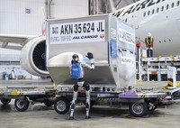 A humanoid robot pushes a cargo container during a media demonstration at Haneda airport in Tokyo on April 27, 2026. (Kyodo)