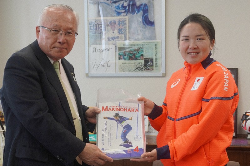 自身が表紙を飾る「広報まきのはら」4月号を杉本基久雄市長（左）から受け取る坂下恵里さん＝静岡県牧之原市役所で2026年4月28日、藤倉聡子撮影