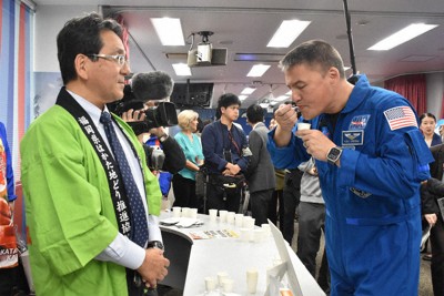 福栄組合の中垣誠社長（左）の前で、宇宙日本食に認証された「はかた地鶏ともち麦のお粥」を試食するチェル・リンドグレン宇宙飛行士＝福岡市中央区の福岡アメリカンセンターで2026年4月28日、宗岡敬介撮影