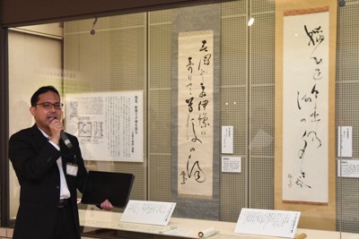 極堂の俳句をしたためた掛け軸の前で、「ほとゝぎす」について解説する平岡瑛二学芸員＝松山市の市立子規記念博物館で2026年4月24日午後2時41分、狩野樹理撮影