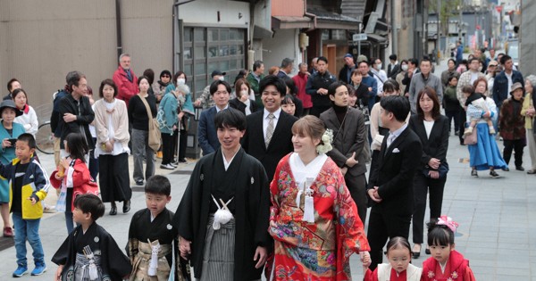 花嫁道中で商店街の通りをゆっくりと歩く比留間希星さん（中央左）とサヴェンコ・ヴァレリヤさん（同右）＝石川県七尾市で2026年4月29日午前9時23分、岩本一希撮影