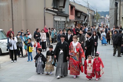 花嫁道中で商店街の通りをゆっくりと歩く比留間希星さん（中央左）とサヴェンコ・ヴァレリヤ（同右）さん＝石川県七尾市で2026年4月29日午前9時23分、岩本一希撮影