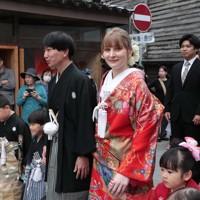 花嫁道中で商店街の通りをゆっくりと歩く比留間希星さん（中央左）とサヴェンコ・ヴァレリヤ（同右）さん＝石川県七尾市で2026年4月29日午前9時16分、岩本一希撮影