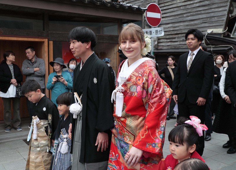 花嫁道中で商店街の通りをゆっくりと歩く比留間希星さん（中央左）とサヴェンコ・ヴァレリヤ（同右）さん＝石川県七尾市で2026年4月29日午前9時16分、岩本一希撮影