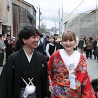 花嫁道中で商店街の通りをゆっくりと歩く比留間希星さんとサヴェンコ・ヴァレリヤさん＝石川県七尾市で2026年4月29日午前9時8分、岩本一希撮影
