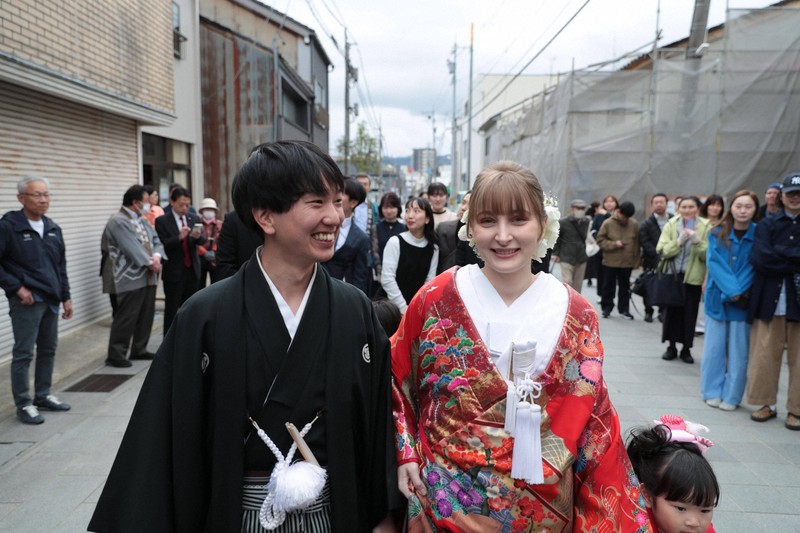 花嫁道中で商店街の通りをゆっくりと歩く比留間希星さんとサヴェンコ・ヴァレリヤさん＝石川県七尾市で2026年4月29日午前9時8分、岩本一希撮影