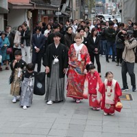 花嫁道中で商店街の通りをゆっくりと歩く比留間希星さん（中央左）とサヴェンコ・ヴァレリヤ（同右）さん＝石川県七尾市で2026年4月29日午前9時20分、岩本一希撮影