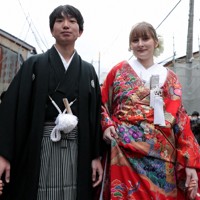 花嫁道中で商店街の通りをゆっくりと歩く比留間希星さん（右）とサヴェンコ・ヴァレリヤ（左）さん＝石川県七尾市で2026年4月29日午前9時7分、岩本一希撮影