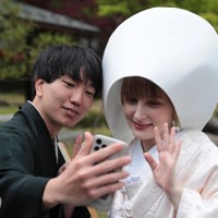 花嫁道中を終え、白むくに着替えたサヴェンコ・ヴァレリヤさん（右）は比留間希星さんと一緒にウクライナにいる父親のオレクサンドルさんとビデオ通話をして花嫁姿を見せた＝石川県七尾市で2026年4月29日午前10時59分、岩本一希撮影