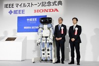 Honda Motor Co. President and CEO Toshihiro Mibe, left,  stands beside the company's P2 bipedal humanoid robot, the predecessor to ASIMO, at a ceremony in Wako, Saitama Prefecture, on April 28, 2026. (Kyodo)