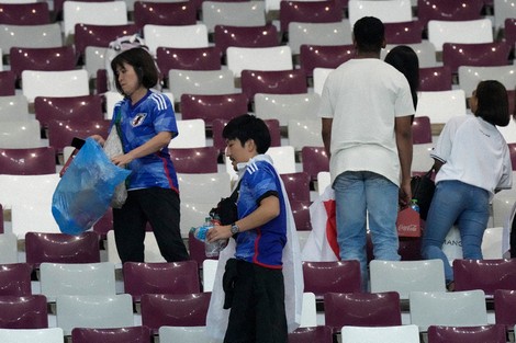 Japan supporters clean the stands at the end of the World Cup group E soccer match between Germany and Japan, at the Khalifa International Stadium in Doha, Qatar, Nov. 23, 2022. (AP Photo/Eugene Hoshiko, File)