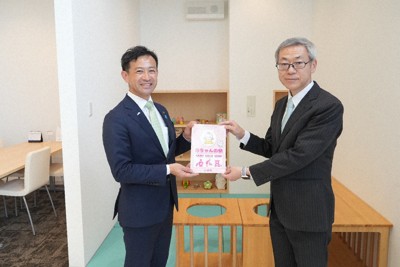 赤ちゃんの駅の認証ステッカーを杉本和範・小浜市長（左）から受け取る福井トヨタの浮田慎太郎社長＝福井県小浜市木崎の福井トヨタ小浜インター店で、高橋隆輔撮影
