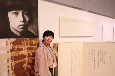 中原中也の詩集を紹介するコーナーで来場を呼びかける広報担当の細田萌美さん＝山口市湯田温泉の中原中也記念館で2026年4月14日午後1時35分、脇山隆俊撮影