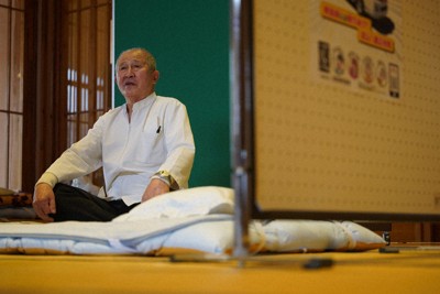 和倉温泉にある日帰り入浴施設「総湯」内の休憩スペースに設けられたマッサージコーナーで客を待つ川崎秀雄さん。結局、この日は利用した客はいなかった＝石川県七尾市で、岩本一希撮影